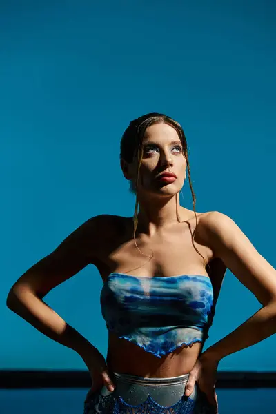 Eine junge Frau im schicken Crop Top posiert am Pool und genießt die Sommersonne. — Stockfoto