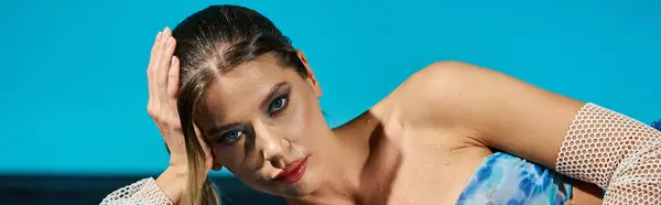 Una joven vestida de moda posa junto al agua de la piscina, irradiando vibraciones de verano. - foto de stock