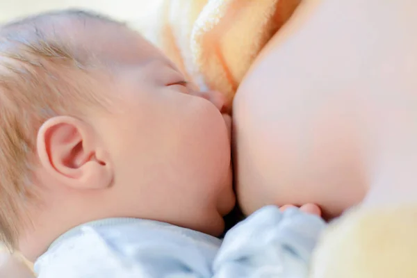Foto de Breastfeeding baby close up. Pretty mother holding her