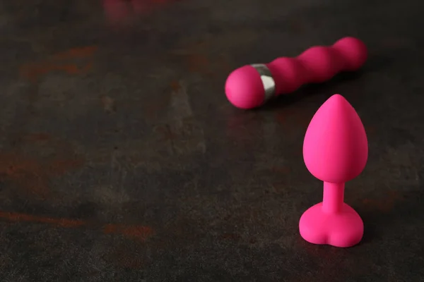 Sex toy. Black butt plag and donut on a pink background. Useful